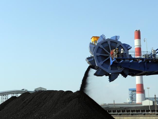 Workers use heavy machinery to sift through coal at the Adani Power company thermal power plant at Mundra some 400 kms from Ahmedabad on February 18, 2011. This is India's first supercritical 660 MW unit. AFP PHOTO / Sam PANTHAKY / AFP / SAM PANTHAKY