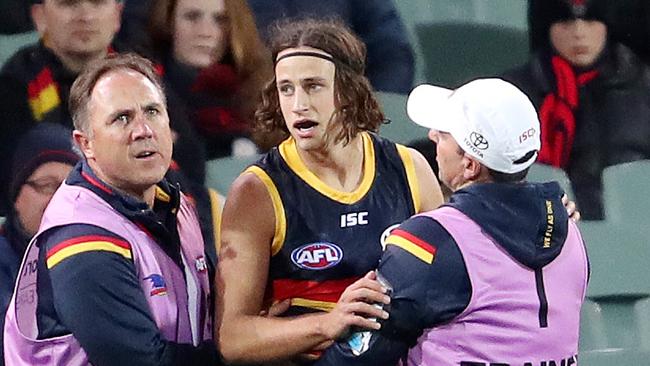 A dazed Will Hamill in the hands of Crows trainers. Picture: Sarah Reed