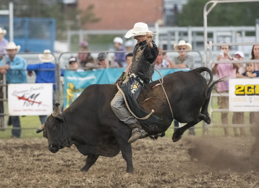 Clint Glass almost makes time in his first ride in the open bull ride at the Lawrence Twilight Rodeo. Picture: Adam Hourigan