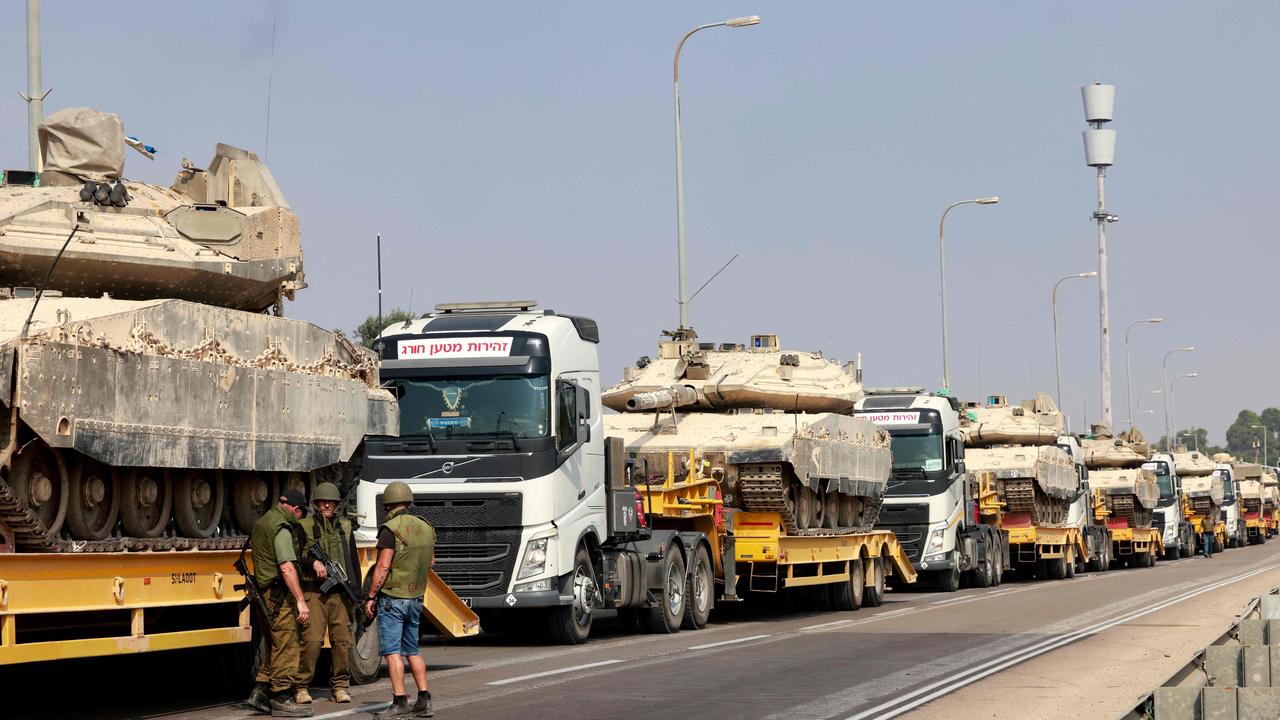 Israeli tanks are transported along a road in an undisclosed location on the border with the Gaza Stip on October 8, 2023. Photo: Menahem Kahana