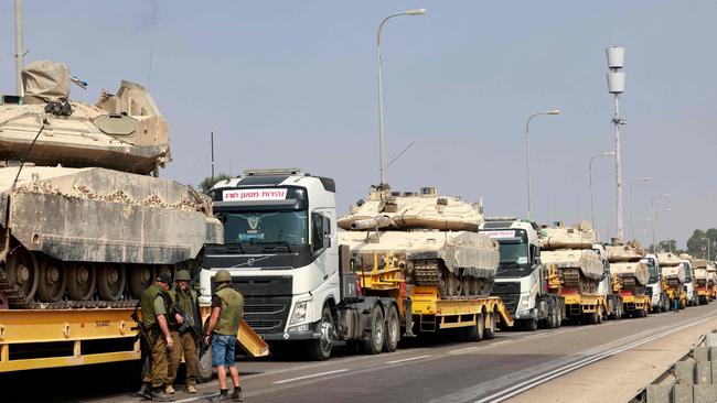 Israeli tanks are transported along a road in an undisclosed location on the border with the Gaza Stip on October 8, 2023. Photo: Menahem Kahana