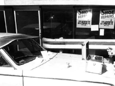 Senior Constable L. Jones examines a vehicle parked behind the Lennons Plaza Hotel.