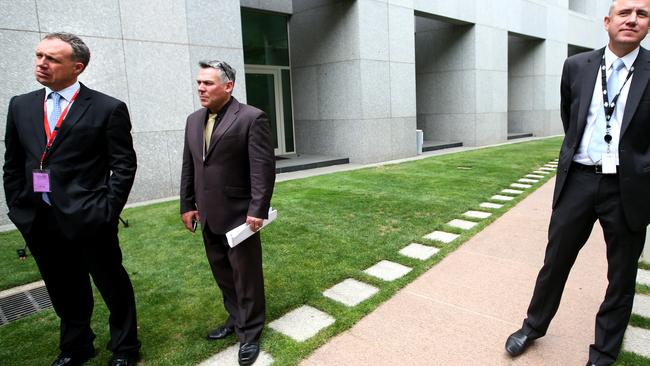 Senator Jacqui Lambie's lawyer Glynn Williams and Chief of Staff Rob Messenger and Ben Oquist listening to Senator Jacqui Lambie speaking at a press conference after she announced she has resigned from the Palmer United Party at Parliament House in Canberra.