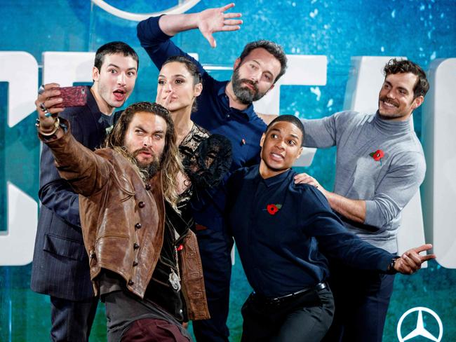 From left, cast members Ezra Miller, Jason Momoa, Gal Gadot, Ben Affleck, Ray Fisher and Henry Cavill pose for a selfie at a photocall for the Justice League in 2017. Picture: AFP