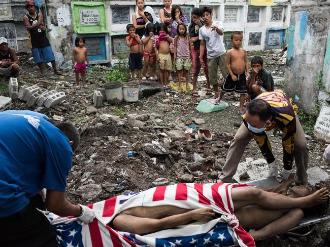 Shanty dwellers living inside the cemetery look at bodies being buried on January 24, 2017 in Manila, Philippines. Many bodies of victims of extrajudicial killings lay unclaimed in a morgue as funerals have had to deal with an upsurge in fatalities from the drug war. Picture: Getty Images/Dondi Tawatao