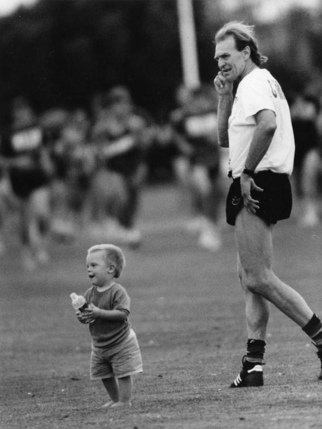 Crows coach Graham Cornes with a small child at Crows training, 1993.