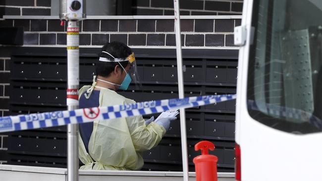 A health worker outside a unit block in Campbelltown during lockdown due to an outbreak of Covid cases. Picture: Jonathan Ng