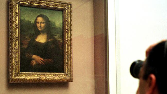 A man takes a photograph of The Mona Lisa by Leonardo da Vinci behind protective glass at the Louvre. Picture: AP