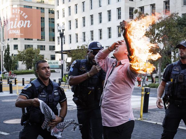 Police help a man who tried to set himself on fire as people demonstrate to mark one year of the war between Hamas and Israel near the White House in Washington, DC, on October 5, 2024. (Photo by Ting Shen / AFP)