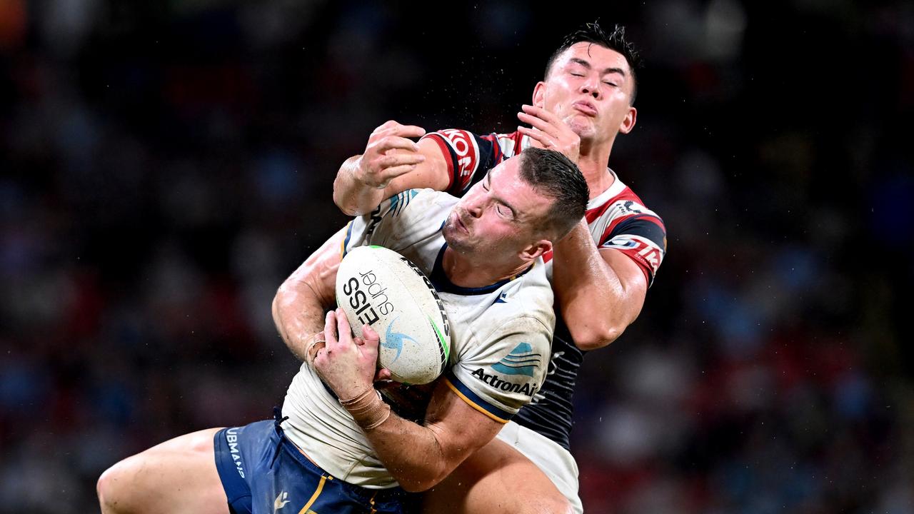 Eels captain Clint Gutherson catches the ball despite the attention of the Roosters’ Joseph Manu at Suncorp Stadium. Picture: Bradley Kanaris/Getty Images