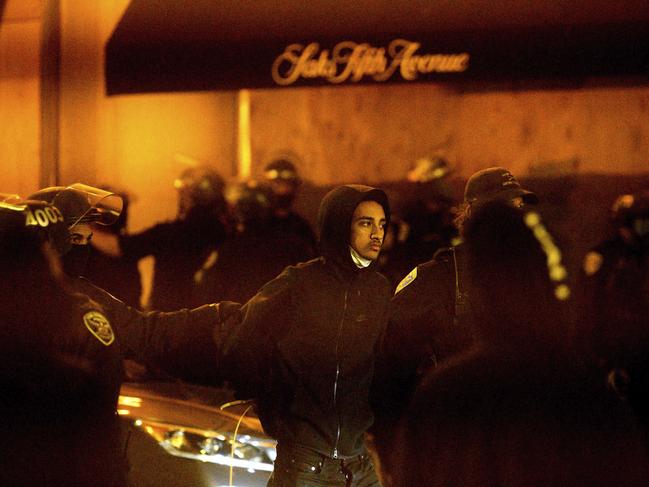 Police officers detain a man outside a vandalised Saks Fifth Avenue store in San Francisco. Picture: Noah Berger