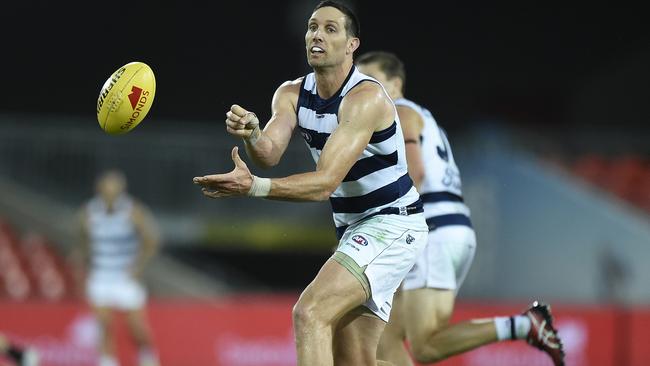 GOLD COAST, AUSTRALIA - AUGUST 14: Harry Taylor of the Cats handballs during the round 12 AFL match between the Geelong Cats and the Port Adelaide Power at Metricon Stadium on August 14, 2020 in Gold Coast, Australia. (Photo by Matt Roberts/Getty Images)