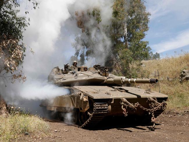 Israeli soldiers ride a tank during a military and aerial supply exercise. Picture: AFP