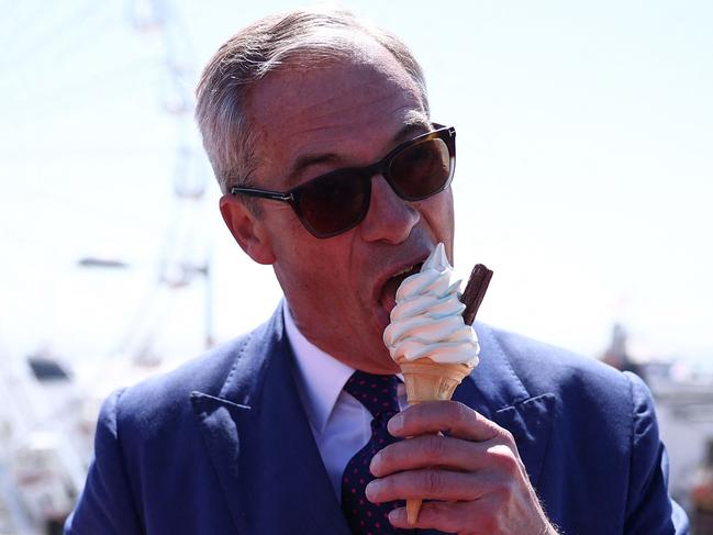 TOPSHOT - Reform UK leader Nigel Farage eats a 99 Flake ice cream in Clacton-on-Sea, eastern England, on July 4, 2024 as Britain holds a general election. (Photo by HENRY NICHOLLS / AFP)