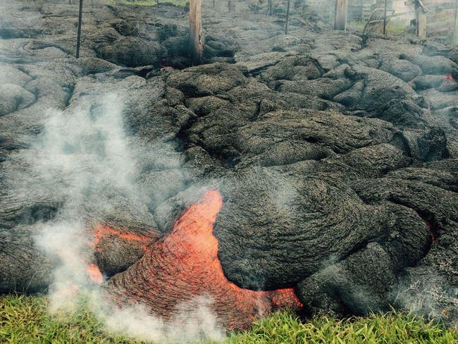 Laval flows from Kilauea volcano towards a village in Hawaii.