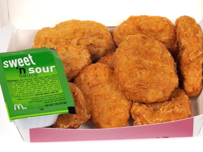 ONE TIME WEB USE FOR NEWS.COM.AU ONLY - FEES APPLY - MUST DOWNLOAD ON OWN ACCOUNT - CF8E07 McDonald's chicken mcnuggets in box packaging and sweet and sour dipping sauce with lid open on white background cut out USA. Picture: Alamy