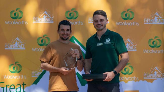 Great Pyramid Race champion Matthew Romano receives his prize from Woolworths Gordonvale's store manager Geoff Pearcy. Picture: Tate Media