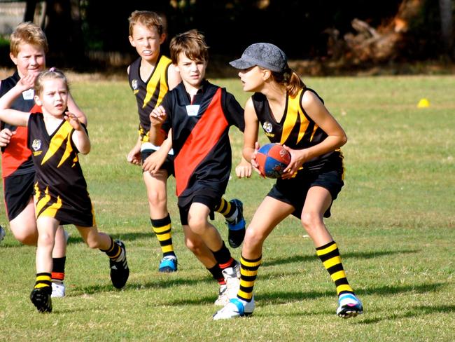 Gold Coast Suns AFLW player Lauren Bella pictured at the age of 10 playing for a Sarina Demons-Bakers Creek combination side with brother William Bella (middle in yellow and black) who was 8. Photo: Supplied.