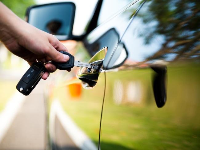 Woman putting key in car door. Could also be used for person stealing a car