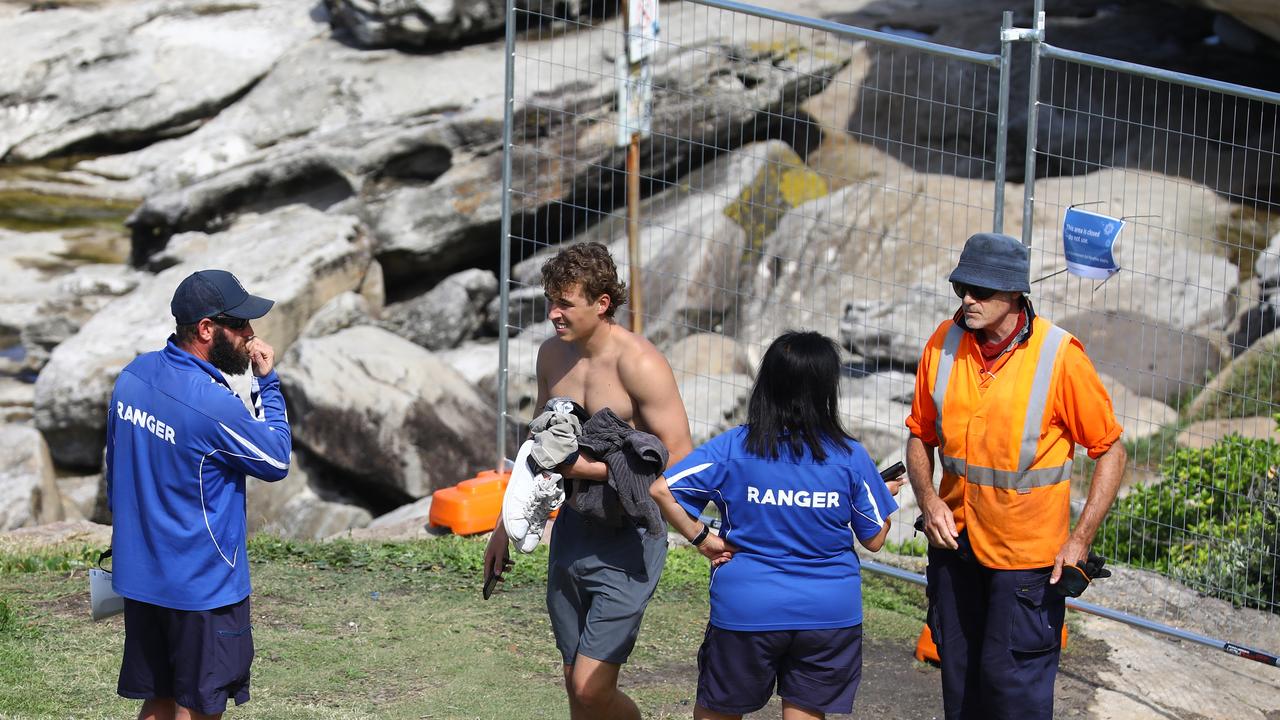 Frustrated council rangers move the swimmers on.