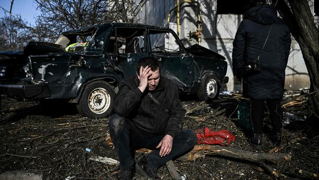 A man sits outside his destroyed home after bombings on the eastern Ukraine town of Chuguiv on February 24. Picture: AFP