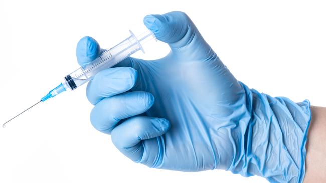 Hand with blue glove holding a syringe blue solute white background