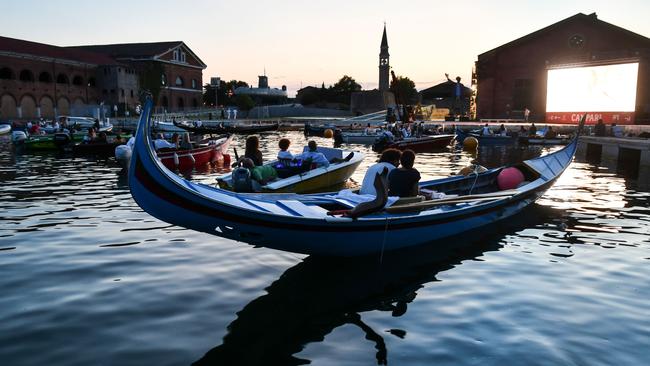 People stay distanced from other in gondolas and other boats as they watch the film The Prestige at Barch-in, a floating drive-in in Venice, late last month. Picture: AFP