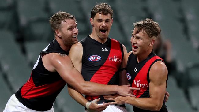 Daniher celebrates one of his three goals with teammates. Picture: James Elsby/AFL Photos via Getty Images