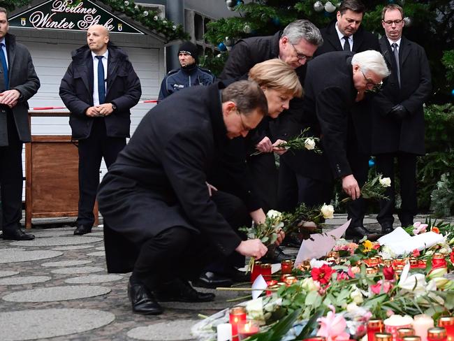 Berlin's mayor Michael Mueller, German Chancellor Angela Merkel, Interior Minister Thomas de Maiziere and Foreign Minister Frank-Walter Steinmeier lay flowers at a makeshift memorial. Picture:  AFP