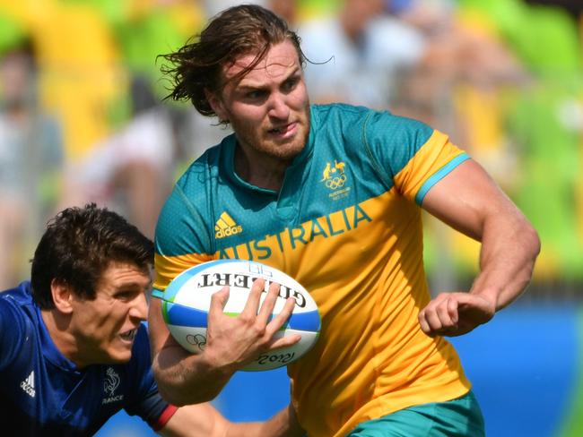 Australia's Lewis Holland runs with the ball in the men’s rugby sevens match between Australia and France during the Rio 2016 Olympic Games at Deodoro Stadium in Rio de Janeiro on August 9, 2016. / AFP PHOTO / Pascal GUYOT