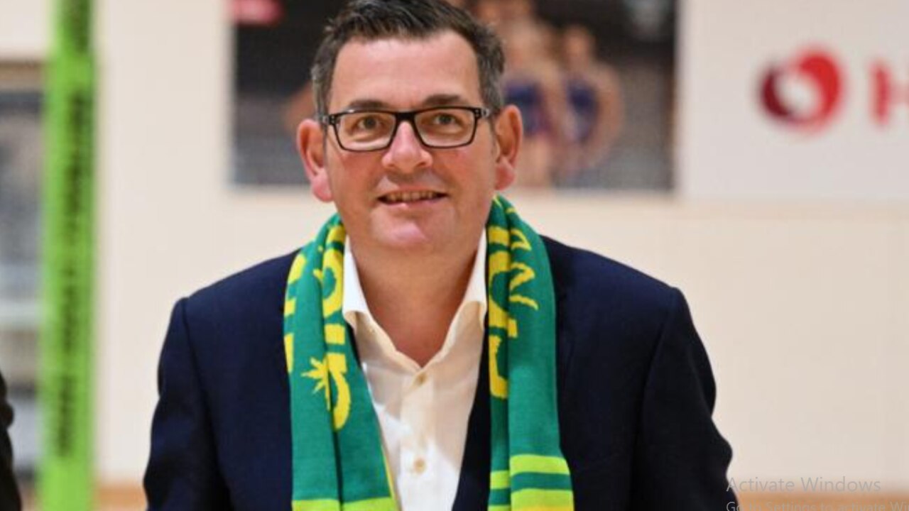 Happy Dan Andrews wears his netball scarf at last year’s sponsorship bailout announcement