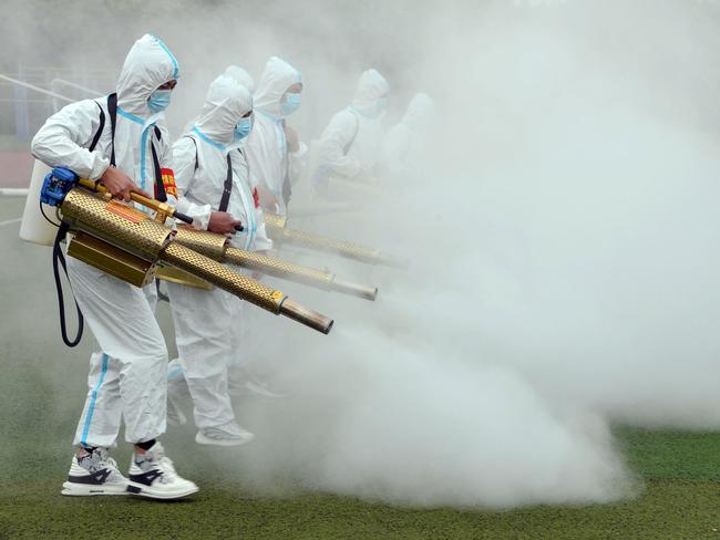 Staff spray disinfectant at a school ahead of the new semester in Bozhou in China’s eastern Anhui province. Picture: AFP