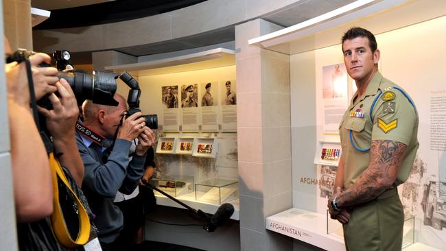 Corporal Ben Roberts -Smith VC poses for the camera's in front of his Victoria Cross display at the Australian War Memorial in Canberra in 2011.