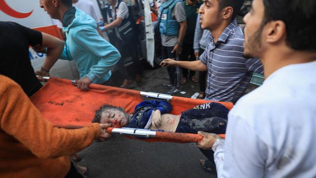 Palestinians transport an injured boy into an ambulance after Israeli bombardment in the southern Gaza Strip earlier in the week. Picture: Mahmud Hams/AFP