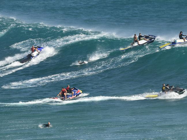 Jetski riders prepare to tow surfers on to waves at Kirra on the Gold Coast , Friday, February 22, 2019.  Huge swells and high tides are pummelling south-east Queensland beaches as Cyclone Oma sits off the Queensland coast. (AAP Image/Dave Hunt)