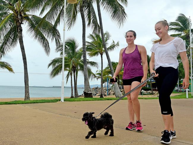 Strand Cyclone Debbie day. Sisters, (L) Hannah Kaesehagen 27yo of Melbourne and  Sophie Kaesehagen 19yo of Belgian Gardens walk with 'Digby' along the Strand.