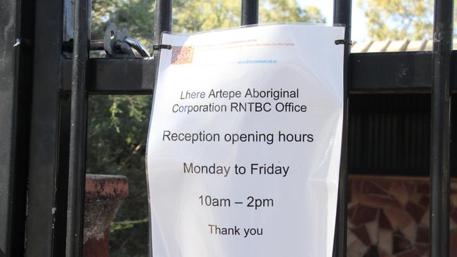 A sign with the opening hours on a padlocked gate at the Lhere Artepe Aboriginal Corporation on Gap Rd in Alice Springs. Picture: Gera Kazakov
