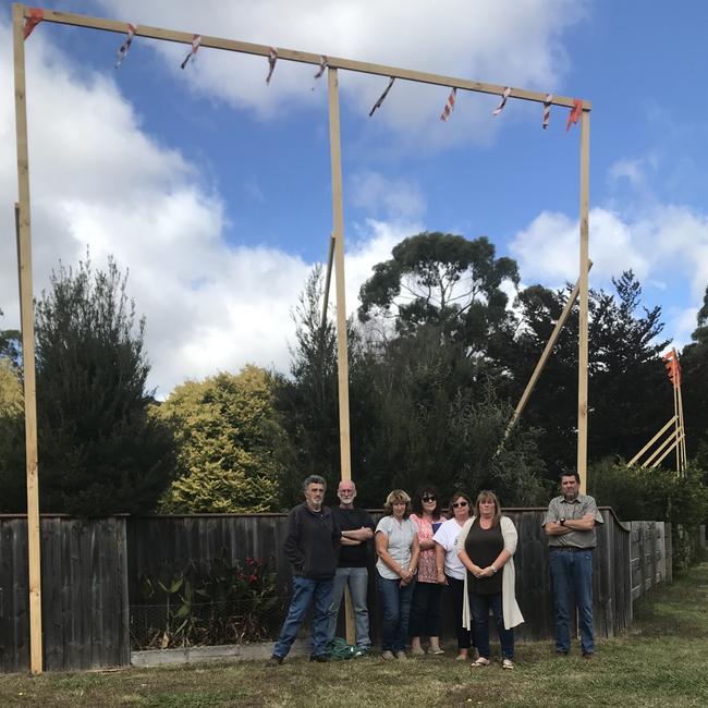 Leith residents under a timber structure which shows how high the proposed overpass would be outside Tony Downey's property