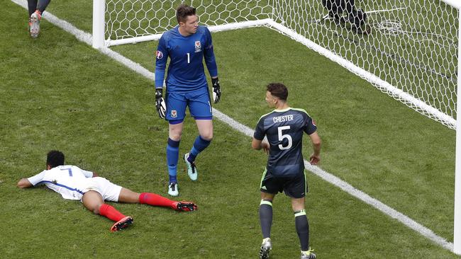 England's Raheem Sterling, left, sits on the floor after failing to score.