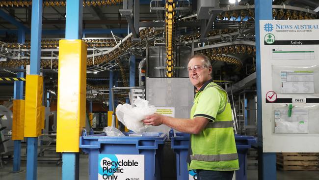 Dean Gray publishing supervisor with plastic being put into the recycle bin. Picture: Nikki Davis-Jones