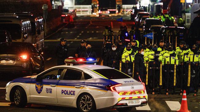 A police car drives past barricades set up by police at a road leading to the South Korean Presidential Office and the Defence Ministry in Seoul on December 4, 2024, after South Korea President Yoon Suk Yeol declared martial law. South Korea's President Yoon Suk Yeol on December 3 declared martial law, accusing the opposition of being "anti-state forces" and saying he was acting to protect the country from "threats" posed by the North. (Photo by ANTHONY WALLACE / AFP)