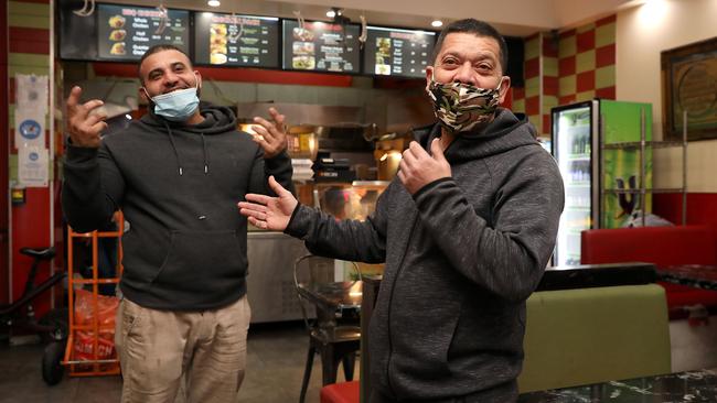 Lakemba chicken shop owner Ahmad El Naboulsi, left, argues with his friend Maer Abbas about the merits of vaccination. Picture: Jane Dempster