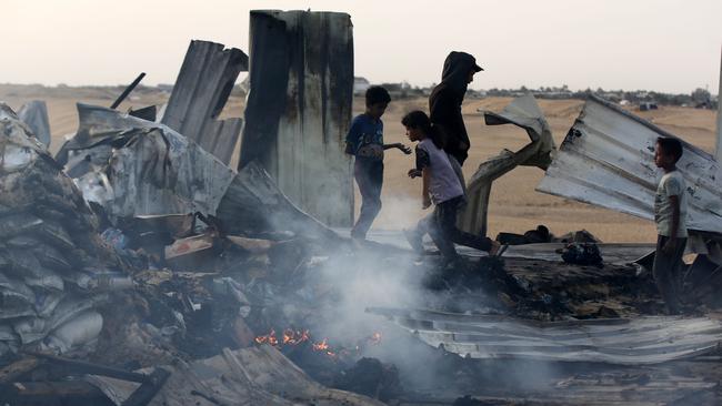 Palestinians observe the destruction caused by the attacks of Israeli army on tents of displaced Palestinians living near the United Nations Relief and Works Agency for Palestine Refugee warehouses in Rafah, Gaza.