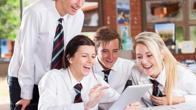 EDUCATION: group of happy high school students using tablet computer . iStock