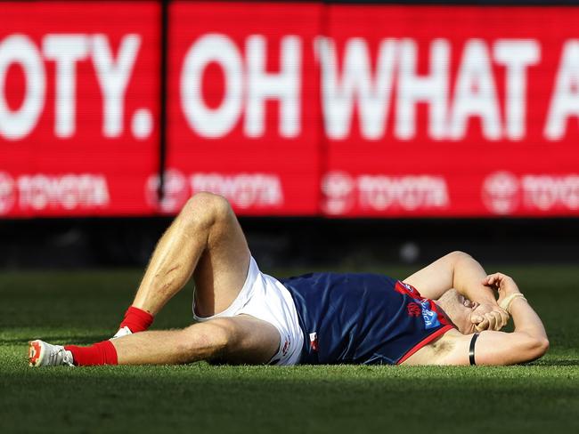 MELBOURNE, AUSTRALIA - MARCH 23: Steven May of the Demons lays on the ground after a heavy collision during the round two AFL match between Hawthorn Hawks and Melbourne Demons at Melbourne Cricket Ground, on March 23, 2024, in Melbourne, Australia. (Photo by Darrian Traynor/Getty Images)