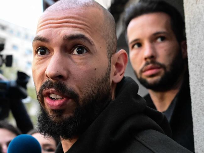 British-US former professional kickboxer and controversial influencer Andrew Tate (front) and his brother Tristan Tate (back R) speak to journalists after having been released from detention in Bucharest, Romania on March 12, 2024, after they appeared in a Bucharest court after Romanian police detained them over UK sex offence charges. A Bucharest court on March 12 granted a request to extradite controversial influencer Andrew Tate to the UK over sex offence charges, but only after the conclusion of legal proceedings in Romania in a separate case. The Bucharest appeals court ruling "orders the execution of the warrant of arrest issued on 19 January 2024" by the Westminster Magistrates' Court, but postpones extradition "until the final resolution of the case" in Romania, which could take years. (Photo by Daniel MIHAILESCU / AFP)