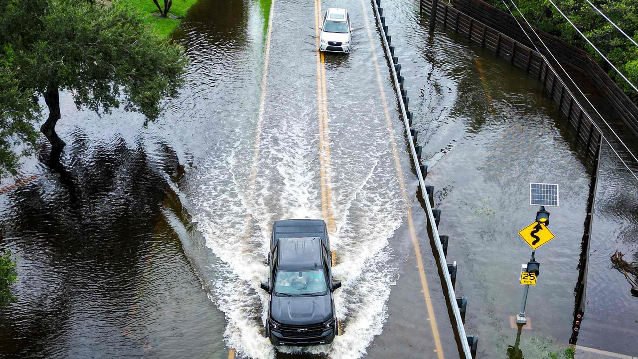 Vehicles attempt to travel on a flooded road in Tampa, Florida, on August 30, 2023, after Hurricane Idalia made landfall. (Photo by Miguel J. Rodriguez Carrillo / AFP)