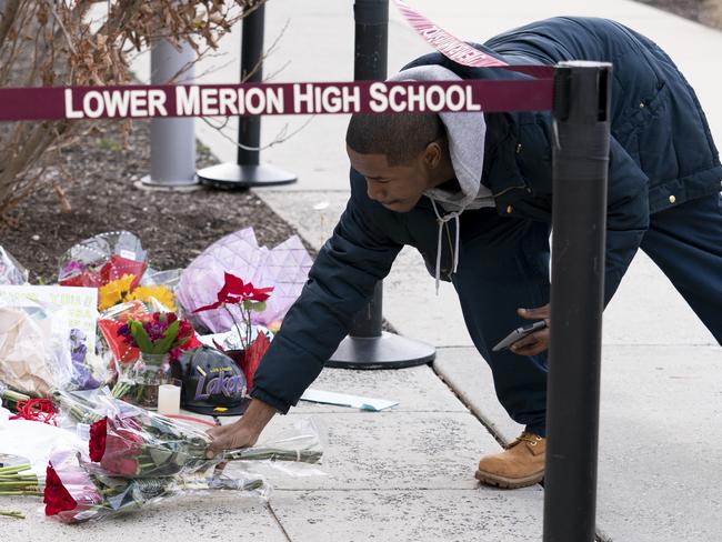 A mourner drops off flowers at Kobe Bryant’s old high school. Picture: AP