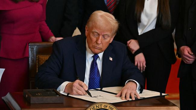 US President Donald Trump signs the Laken Riley Act in the East Room of the White House in Washington, DC, January 29, 2025. The Laken Riley Act -- which mandates the detention of undocumented immigrants charged with theft-related crimes -- is named for a 22-year-old student murdered by a Venezuelan man with no papers who was wanted for shoplifting. (Photo by PEDRO UGARTE / AFP)