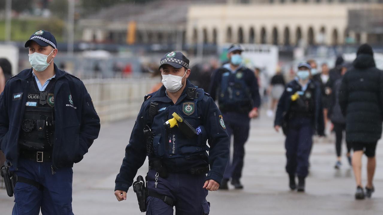 Police at Bondi, as cases climbed to 136. Picture: John Grainger